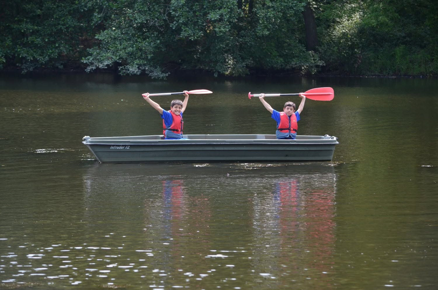 Scouts raising paddles in a canoe on the lake